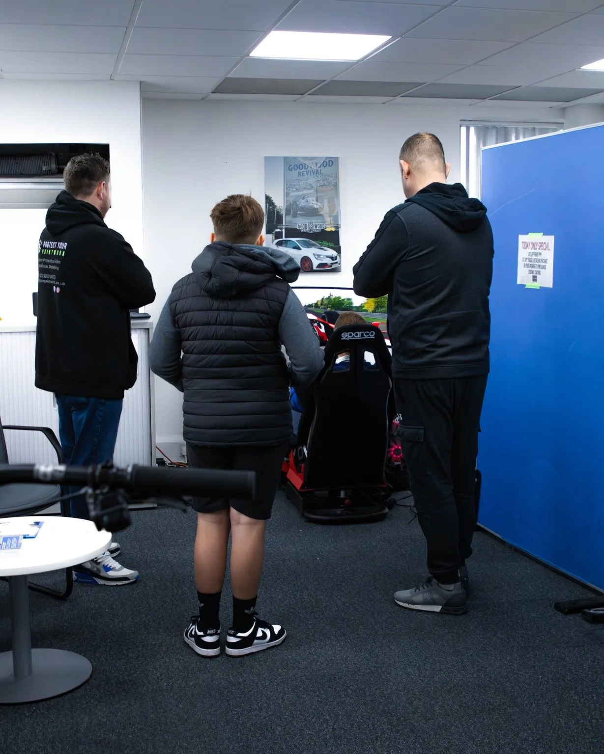 Guests on the race simulator at a Cars and Coffee morning in the studio