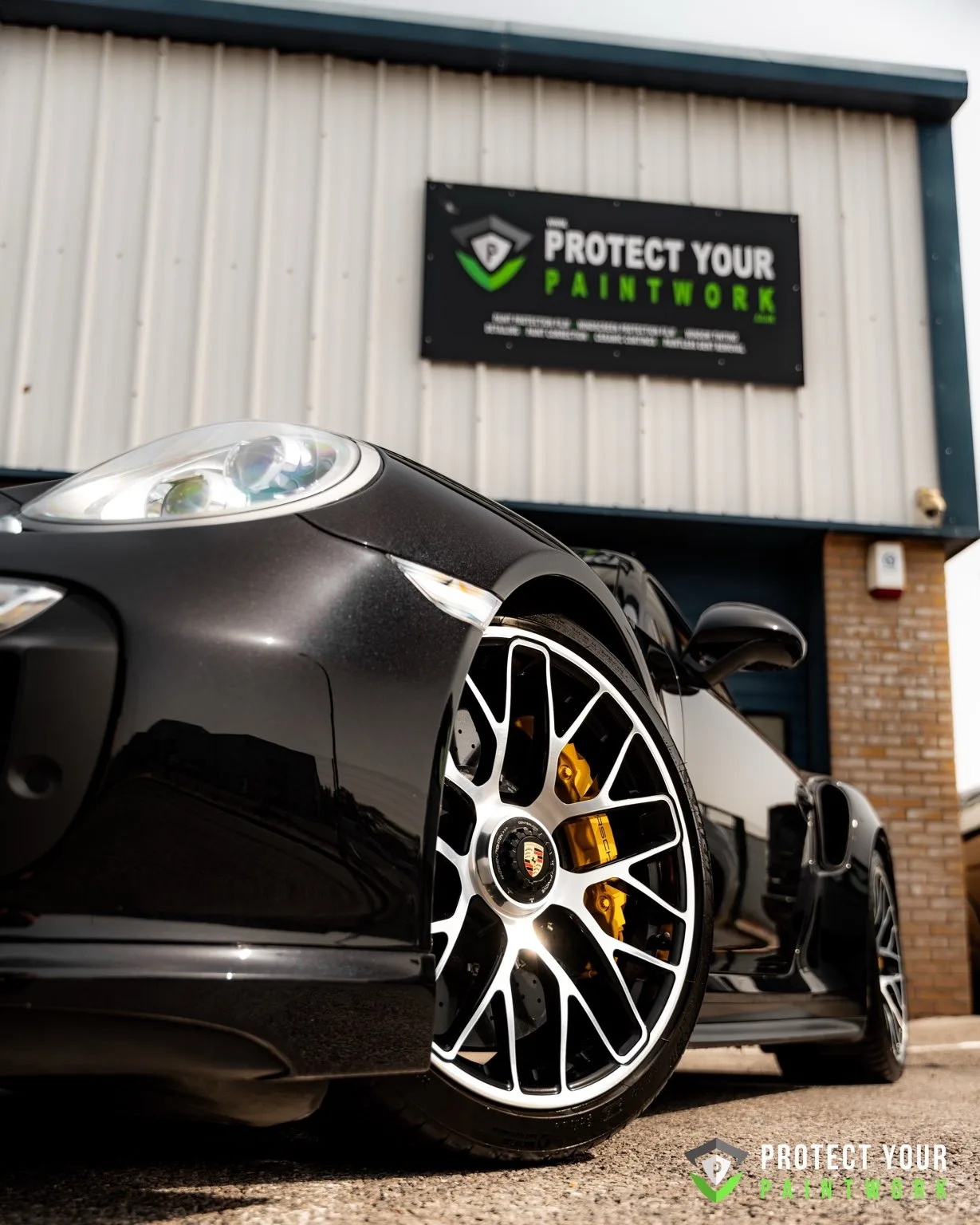 A black Porsche 911 Turbo outside the Protect Your Paintwork unit