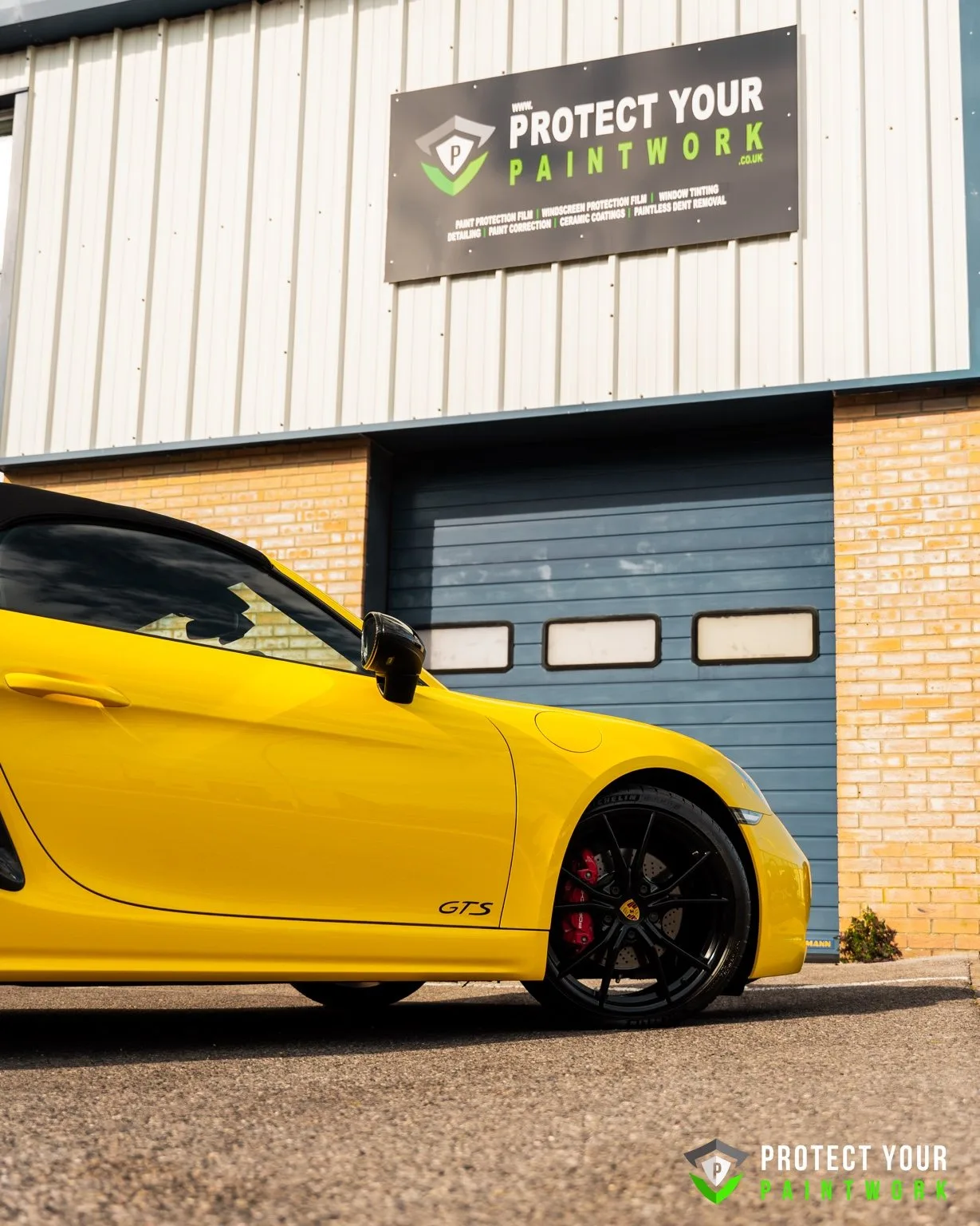 A yellow Porsche outside the Protect Your Paintwork unit